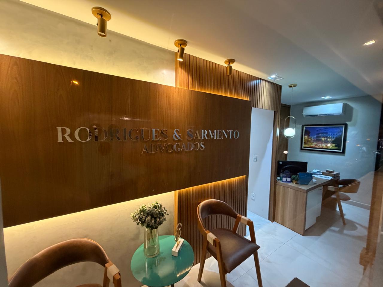 Sala de atendimento do escritório com iluminação dourada e painéis de madeira